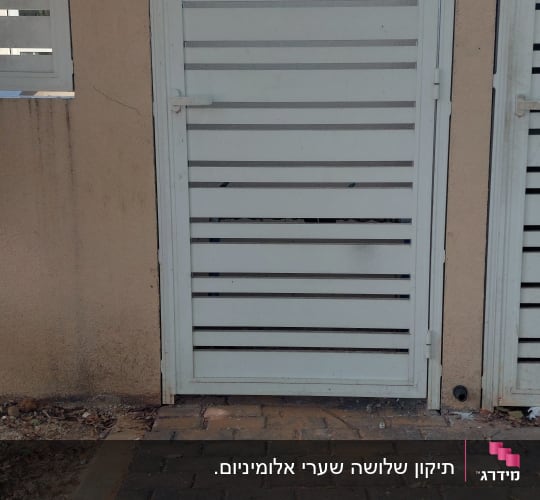 שער אלומיניום ליד שביל מרוצף בלבנים